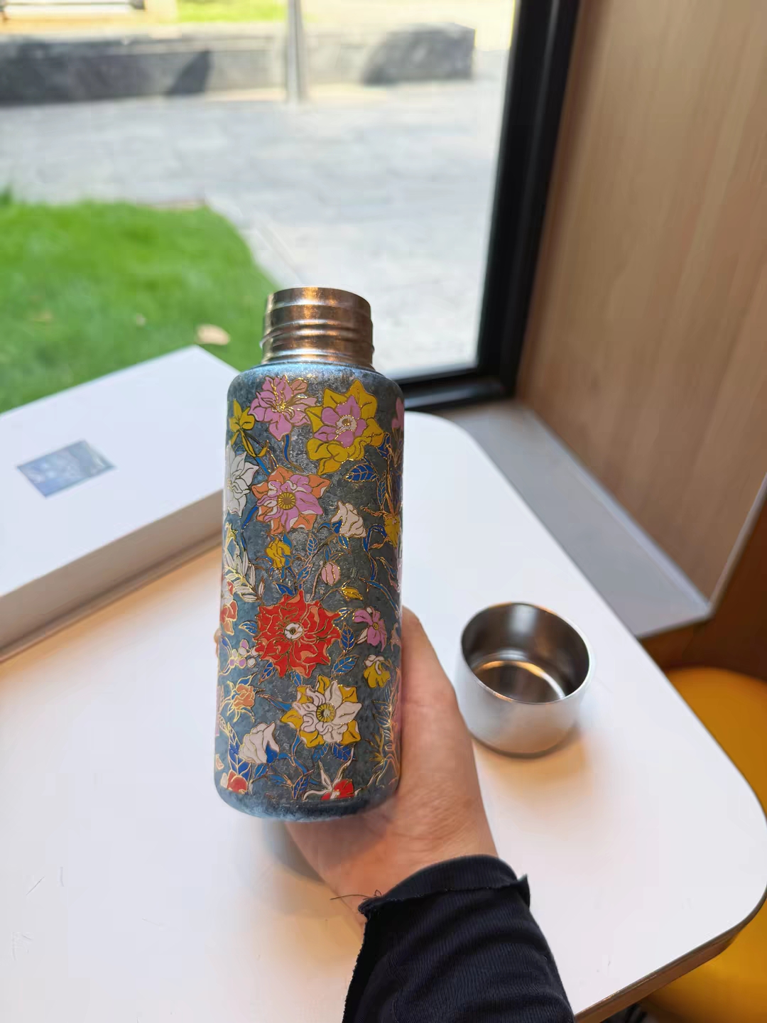 买家手持花卉纹钛杯